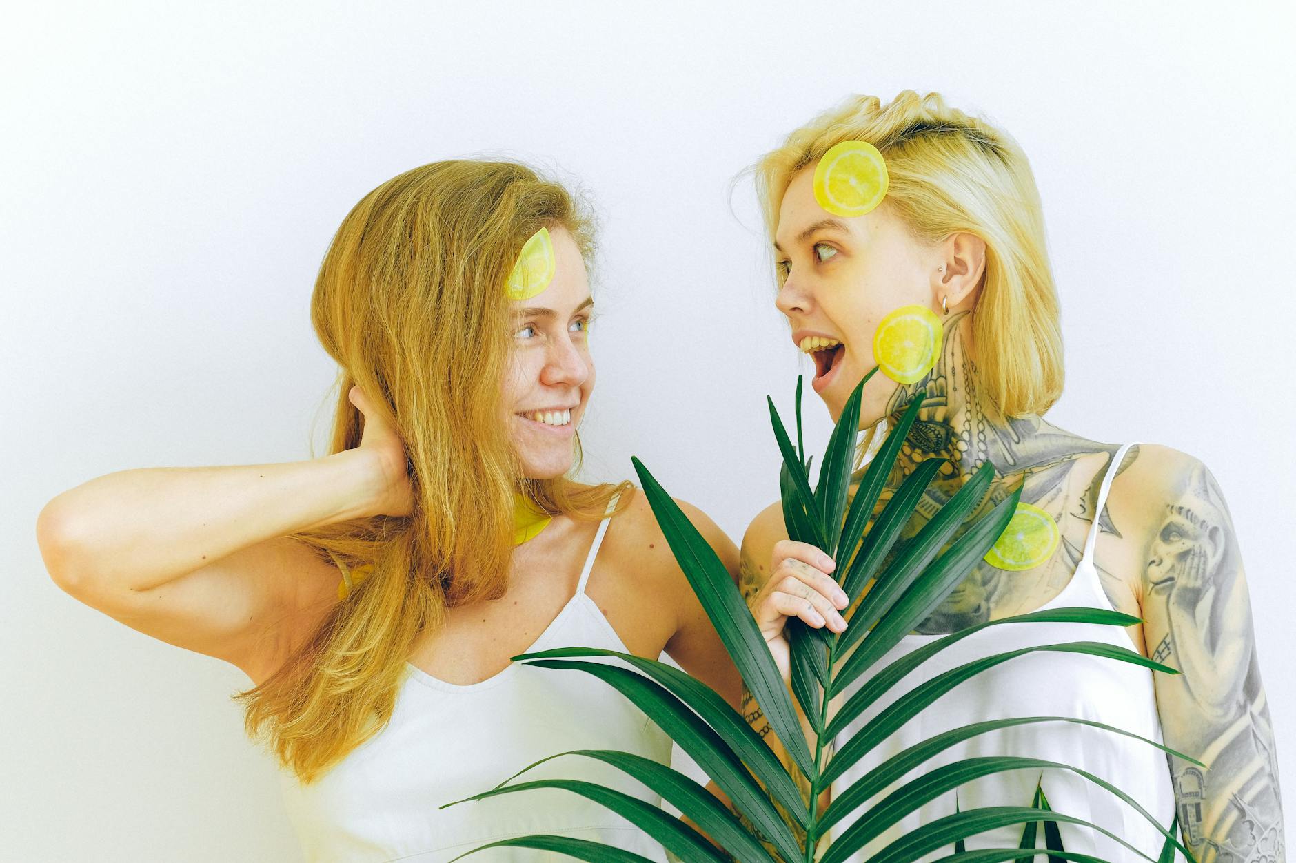 Two women laughing together with fresh lemons, representing joy and reconnection in relationships.