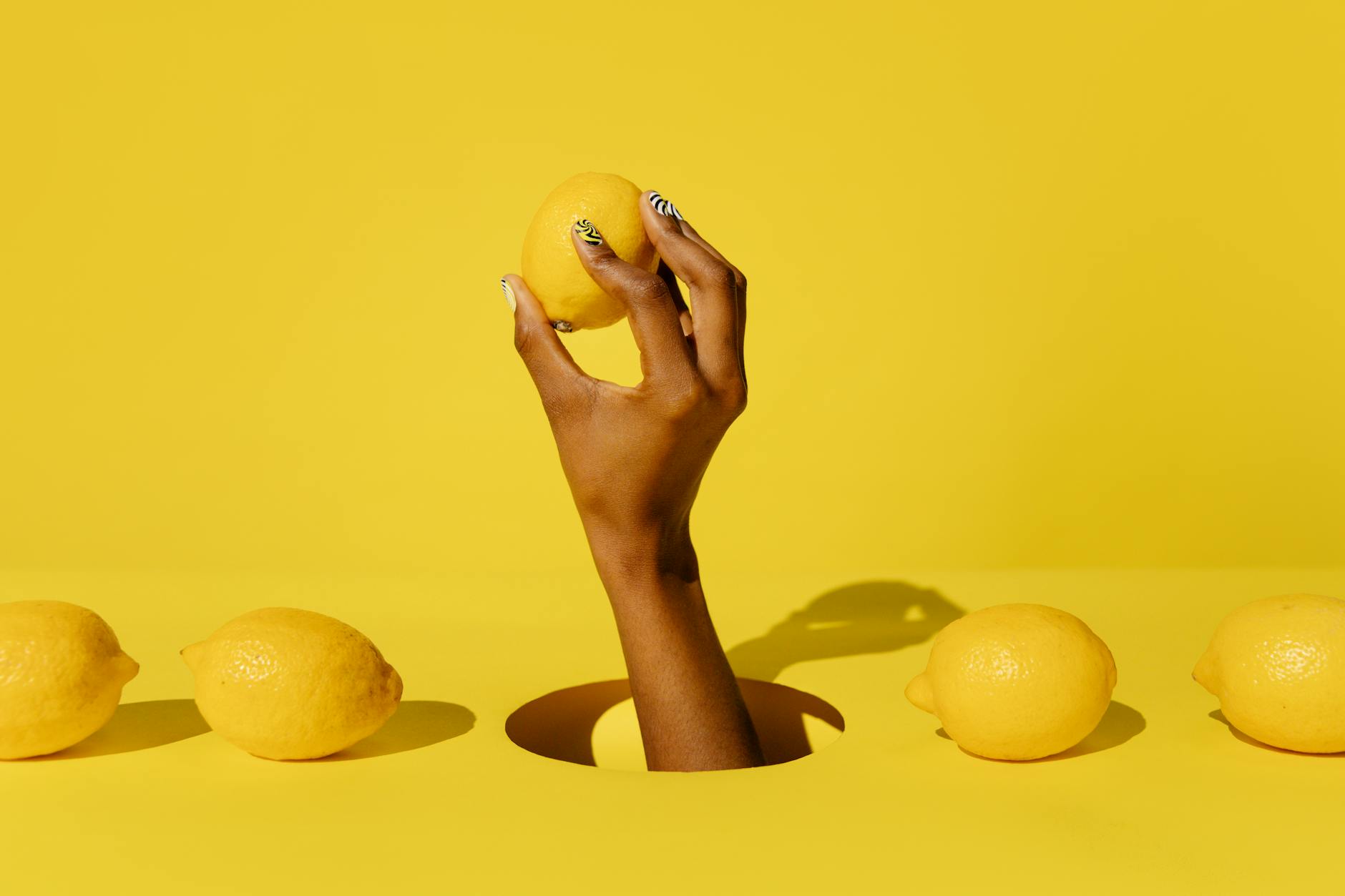 A fresh lemon held against a vivid yellow background, symbolizing renewal and sensory reset