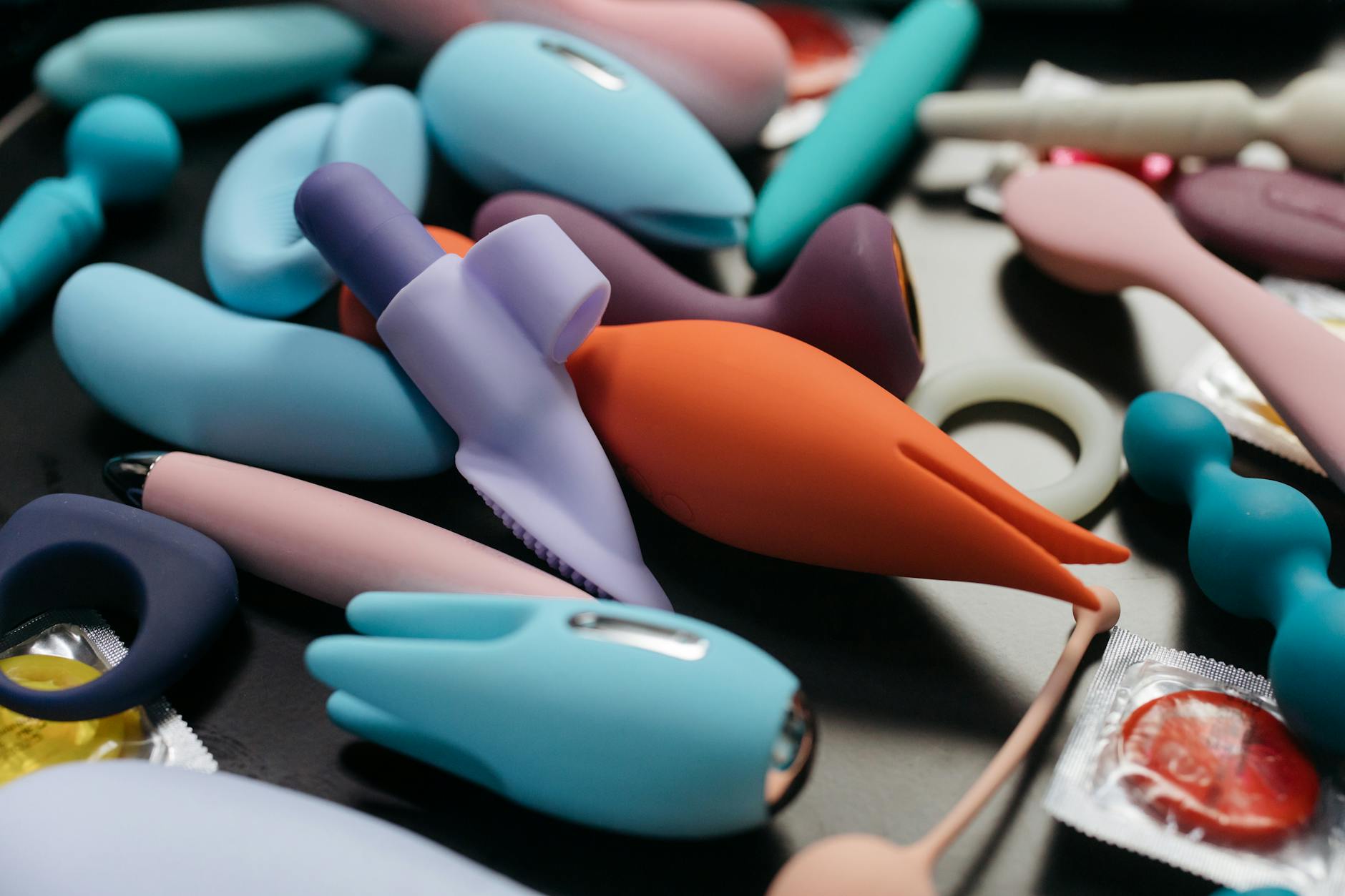 An array of vibrant adult toys including lemon clitoral vibrators and rings in a close-up view.