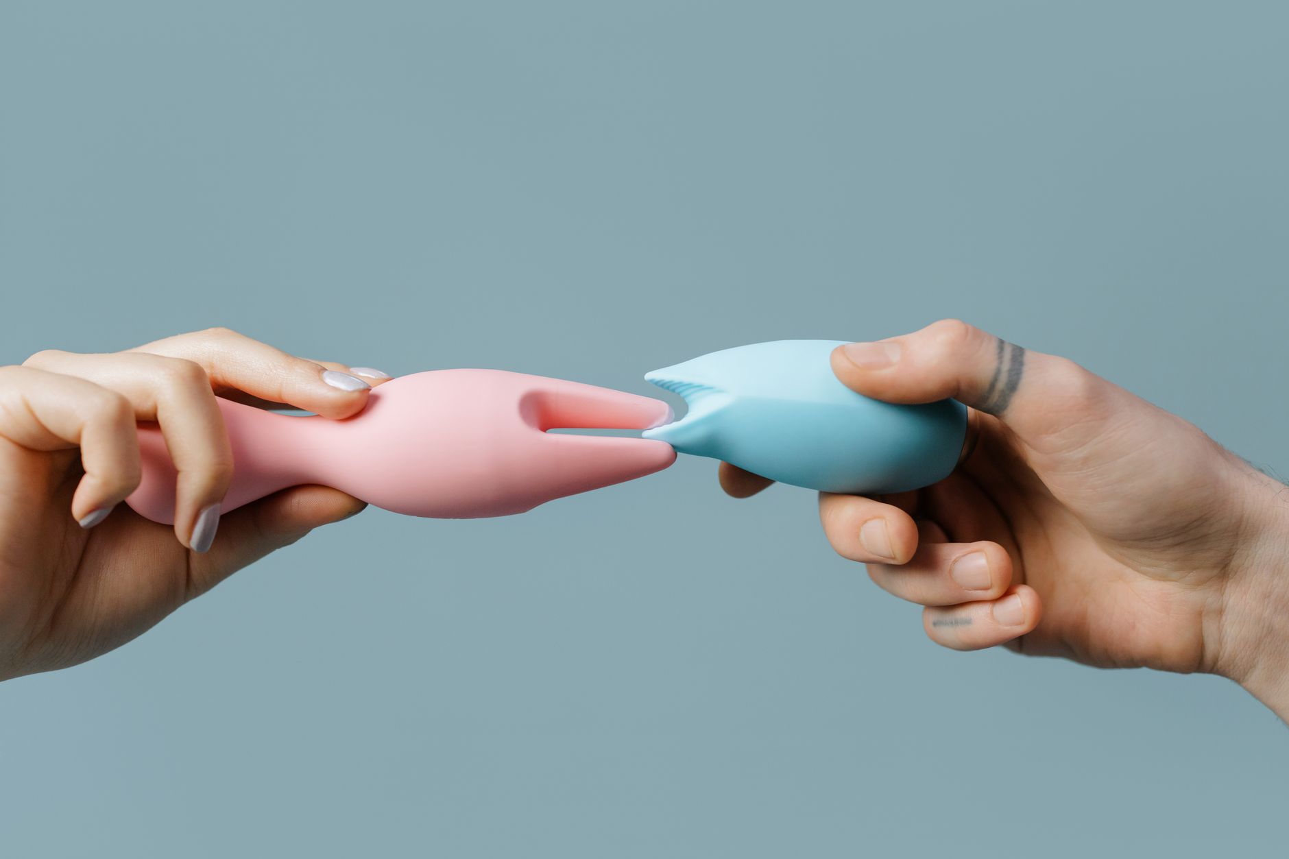 Hands holding pastel-colored silicone lemon clitoral vibrators