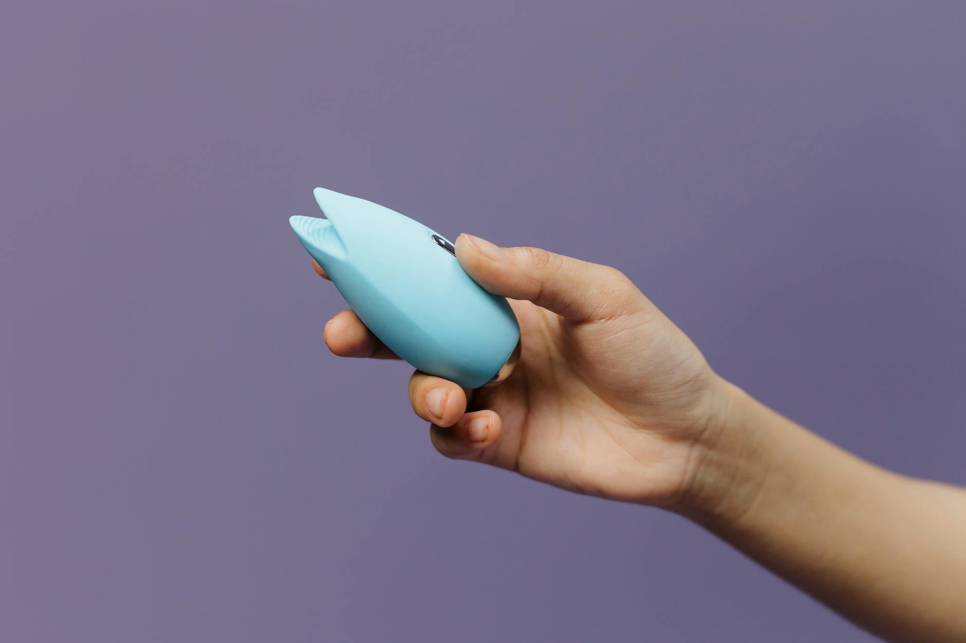 A blue silicone lemon vibrator held in hand, promoting self-care and gradual pleasure exploration.